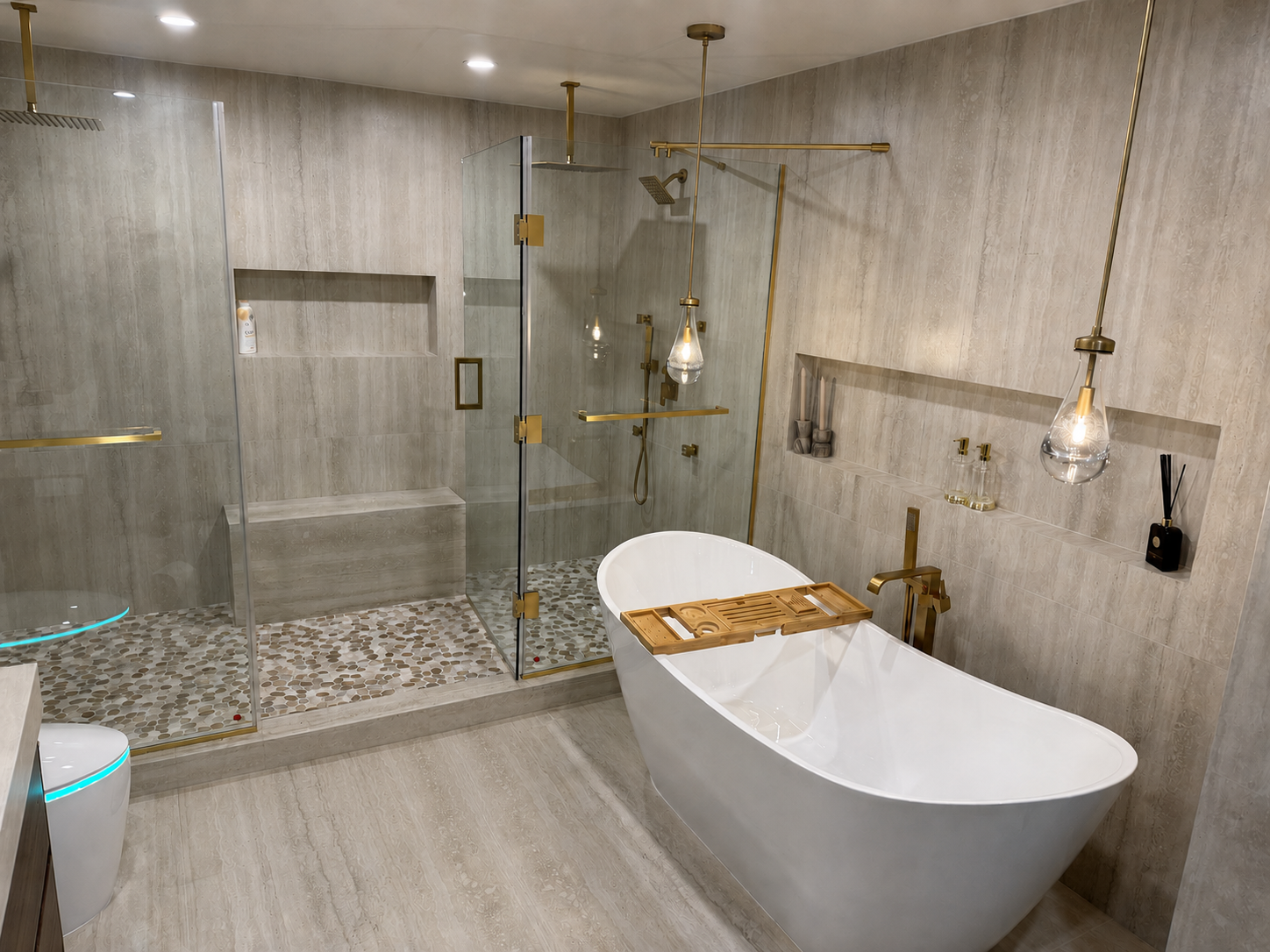 Freestanding soaking tub and frameless glass shower with brass fixtures in bathroom remodel